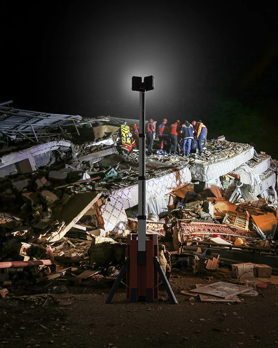 Rescuers working at night on a collapsed structure under a G-COMIN light tower