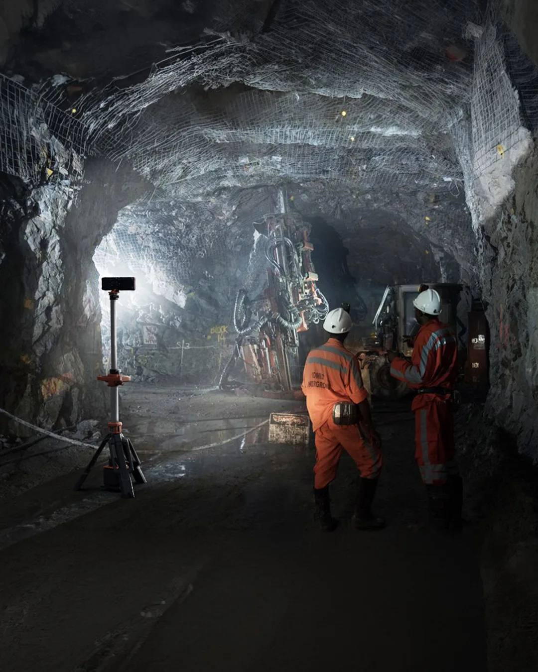 Miners working in a tunnel lit by a G-COMIN tower