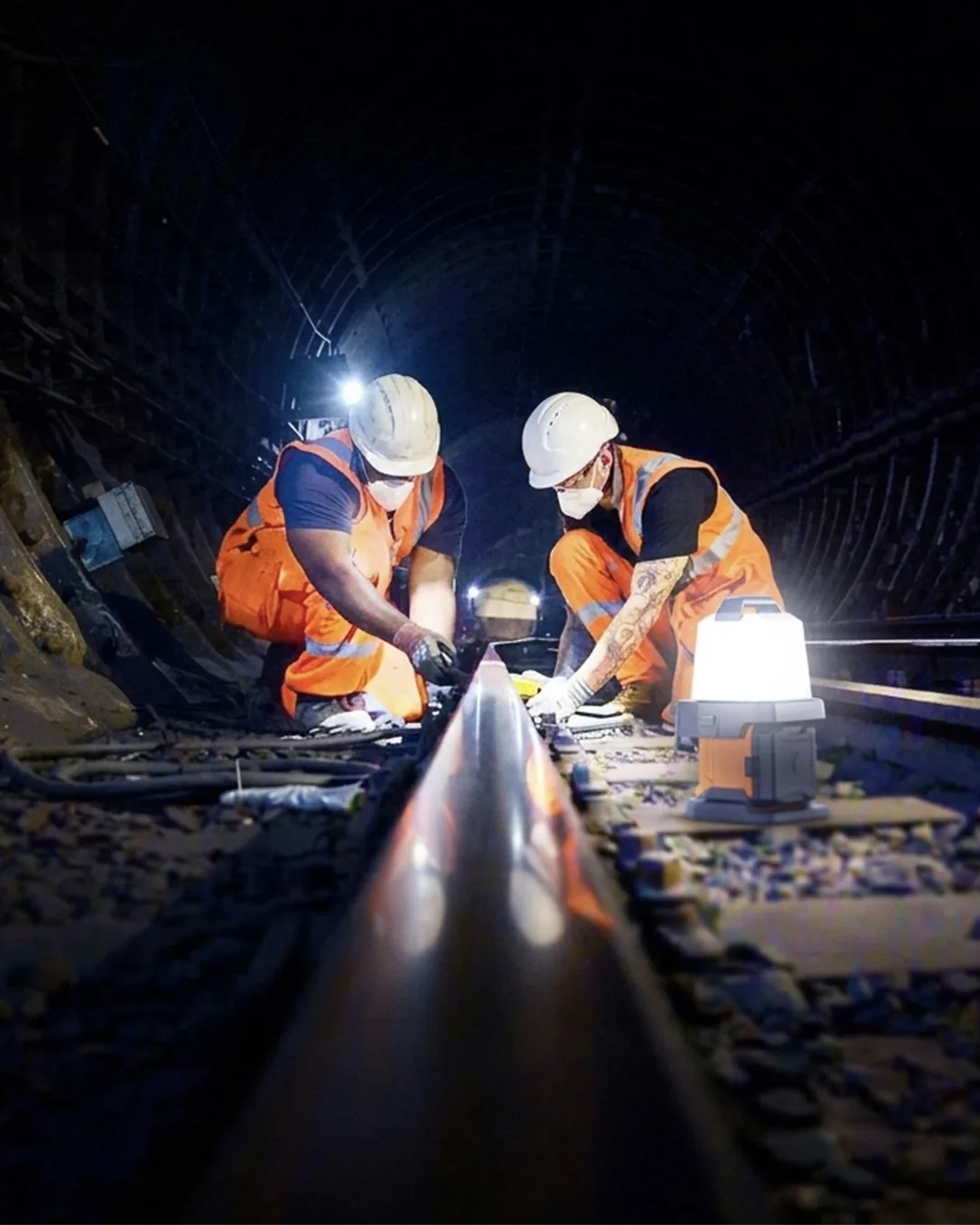 Technicians inspecting a railway track at night with a G-COMIN portable light