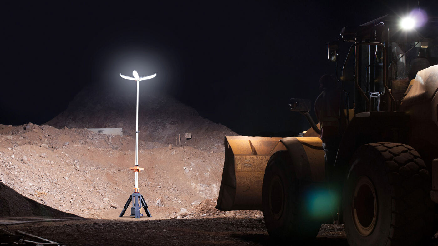 PL-200 tower lighting a nighttime jobsite next to a front loader