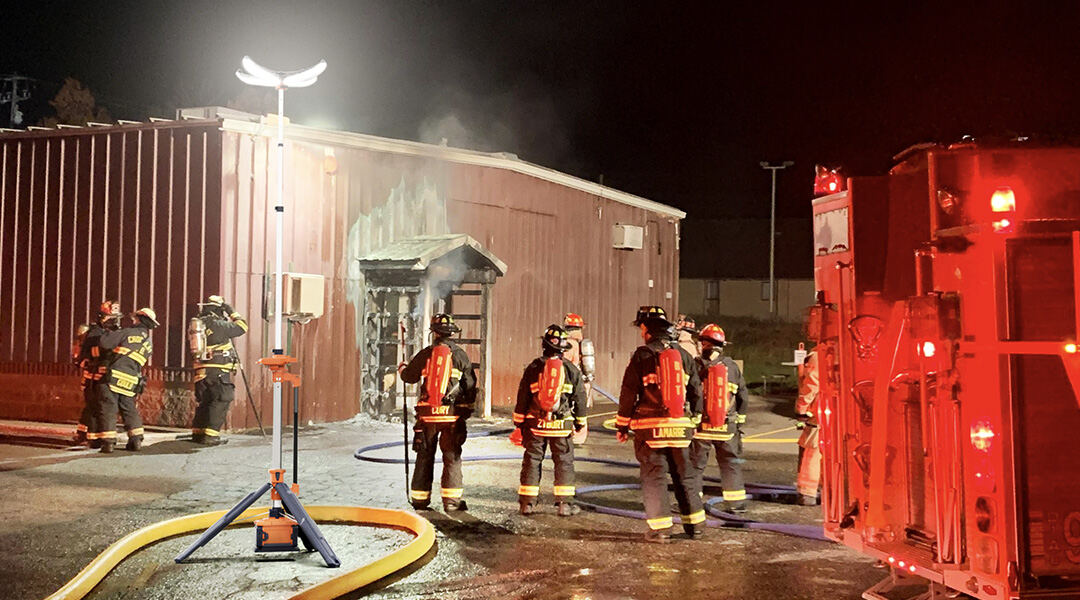 Bomberos atendiendo un incendio iluminados por una PL-300
