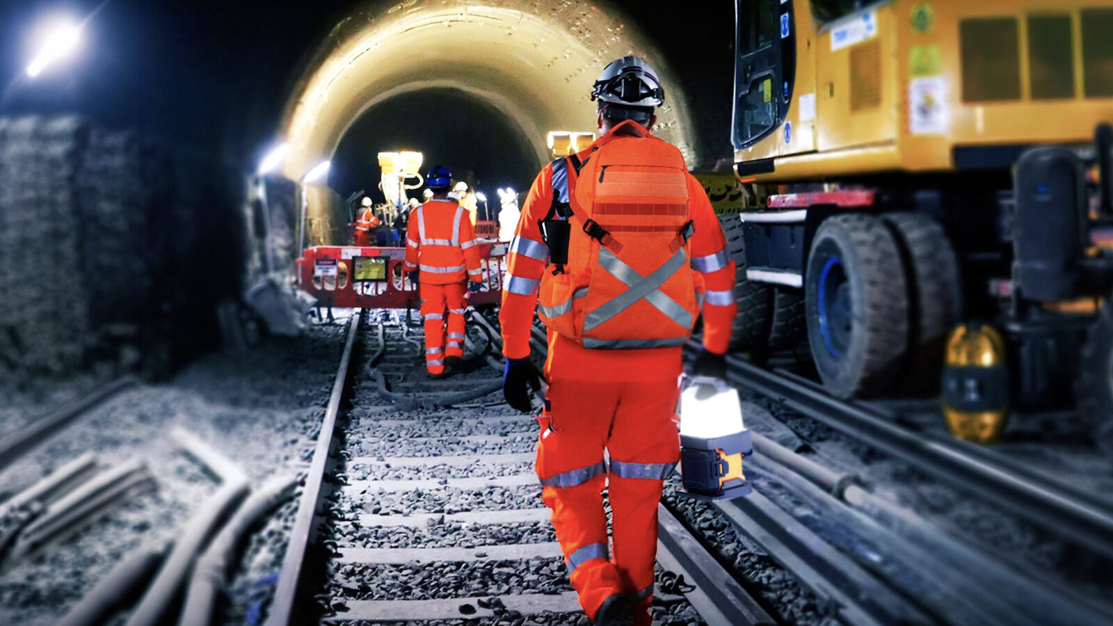 Trabajador caminando por un túnel ferroviario con una PS-200 en la mano